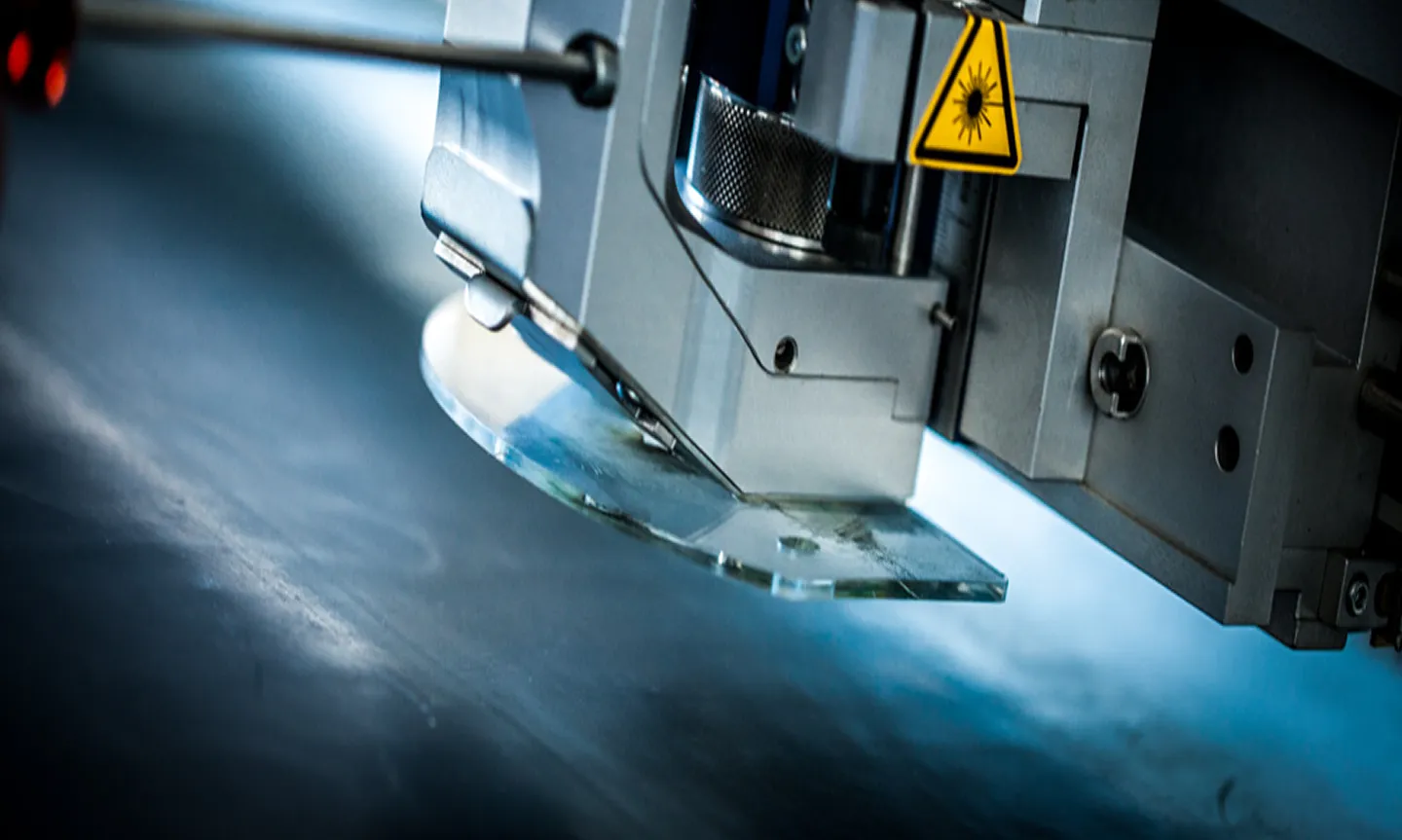 Laserkopf einer Industrie-Laseranlage bei der Bearbeitung von Metall
